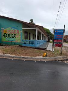 un edificio con un cartel frente a una calle en Pousada Marudá, en Marapanim 2 fotos más