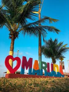 una señal para un parque con palmeras al fondo en Pousada Marudá, en Marapanim