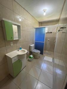 a bathroom with a shower and a sink and a toilet at Hostel e Pousada Vó Lili in Joinville +25 photos