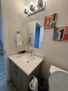 Un baño con lavabo, espejo e inodoro. en 1BHK, Close to Whyte ave, Downtown, UOFA 10633, en Edmonton