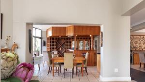 een eetkamer en keuken met een tafel en stoelen bij Fly Me To The Moon Guesthouse in Mosselbaai