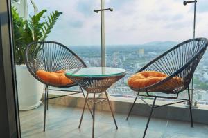 two chairs and a table in front of a window at Sunmie Home Hoàng Huy Commerce Apartment in Hai Phong