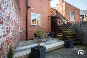a patio with a table and chairs on a brick building at Stylish Cosy Two Bed Apartment - Coast Location in Whitley Bay