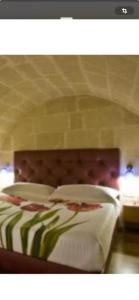 a bedroom with a large bed with a wooden headboard at Labanca's La Perla in Matera