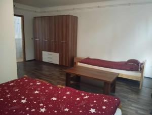 a room with two beds and a wooden cabinet at NADENKA & MGR Vendégház in Alsótelekes