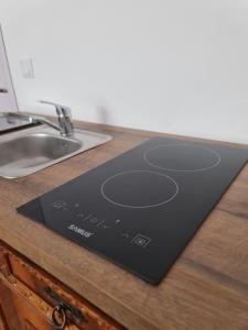 a black cutting board on a counter next to a sink at Luci's House in Jucu de Mijloc