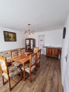 a dining room with a wooden table and chairs at Luci's House in Jucu de Mijloc