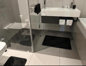 een badkamer met een glazen douche en een wastafel bij Your Private Space in Soweto
