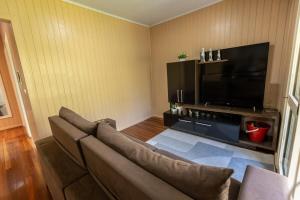 ベント・ゴンサルベスにあるRecanto dos Vinhedosのソファと薄型テレビのあるリビングルーム