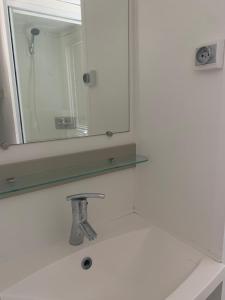 ein Badezimmer mit Spiegel und Waschbecken in der Unterkunft Mobil home 6 pers camping 5 in Montalivet-les-Bains