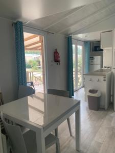 eine Küche, ein Esszimmer mit einem Tisch und einem Tisch sowie eine Küche in der Unterkunft Mobil home 6 pers camping 5 in Montalivet-les-Bains