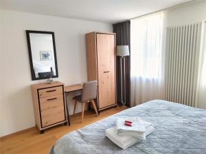een slaapkamer met een bed, een bureau en een spiegel bij Casa Rheinblick - Apartment C in Bazel