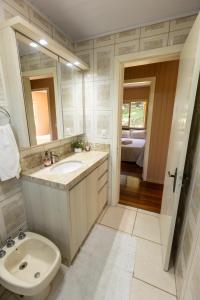 ベント・ゴンサルベスにあるRecanto dos Vinhedosの洗面台、トイレ、鏡のあるバスルーム +72枚の写真