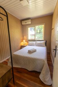 ベント・ゴンサルベスにあるRecanto dos Vinhedosの窓のある小さな部屋のベッド