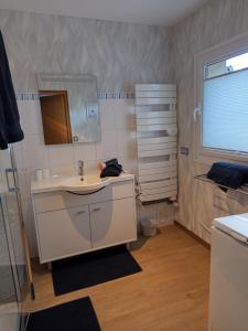 une salle de bain avec un lavabo et un miroir dans l'établissement Gîte 3 étoiles Le Charme Des Cerisiers 8 pers, à Bouvigny-Boyeffles 34 autres photos