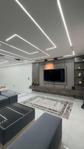 a living room with a couch and a flat screen tv at Three-bedroom apartment in Mohandessin in Cairo