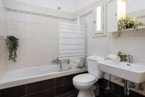 ein weißes Badezimmer mit Toilette und Waschbecken in der Unterkunft Villa Marianthy Kefalonia in Zambelláta + 12 Fotos