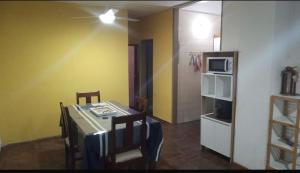 een eetkamer met een tafel en een magnetron bij Alquiler temporal in Cordoba