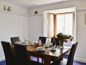 a dining room with a table and chairs and a window at Beacon Cottage in Ivybridge