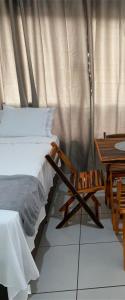 a bedroom with a bed and a wooden table and a chair at Flats Teles 3 in Palmas