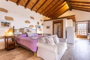a bedroom with a bed and a couch at Casa La Tosca in San Miguel de Abona