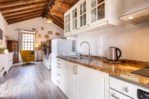 a kitchen with white cabinets and a sink at Casa La Tosca in San Miguel de Abona