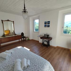 ein weißes Schlafzimmer mit einem Bett und einem Spiegel in der Unterkunft Charme nel borgo - Appartamento Lina in Corniglio