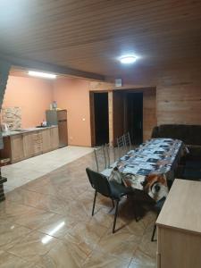 a room with a table and chairs and a kitchen at Sauleskrasti 