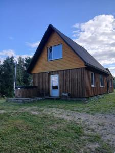 a large wooden barn with a window on the side at Sauleskrasti  +3 photos