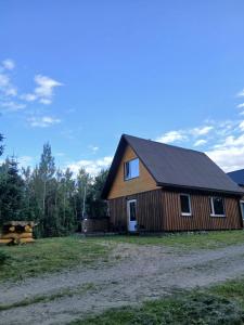 a large wooden barn with a field in front of it at Sauleskrasti 