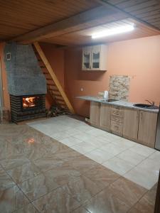 a kitchen with a fireplace in a attic at Sauleskrasti 