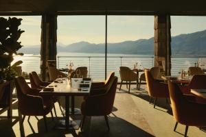 a restaurant with tables and chairs and a view of the water at Cape of Senses in Torri del Benaco +40 photos