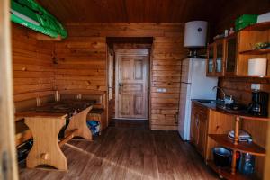 a kitchen with a table in a log cabin at Casuta Verde Bicaz in Bicaz