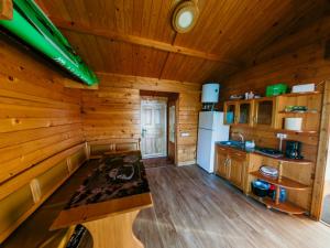 a kitchen with a table in a log cabin at Casuta Verde Bicaz in Bicaz