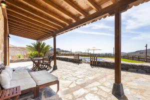 a patio with a couch and chairs on a stone patio at Casa La Tosca in San Miguel de Abona