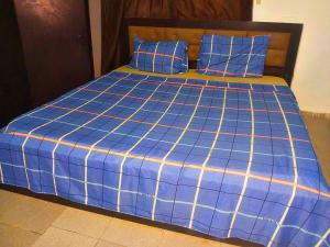 a blue bed with blue sheets and blue pillows at Richbee Hotel and Suites in Abuja