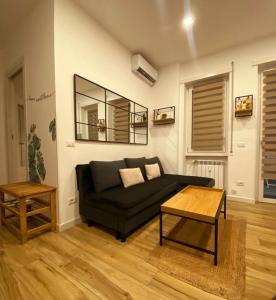 een woonkamer met een zwarte bank en een tafel bij Zefiro Ostia in Lido di Ostia