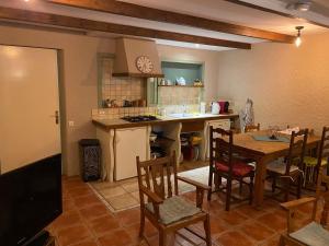 a kitchen and dining room with a table and a tv at Gite Deja Vu in Montcabrier