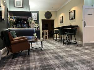 a living room with a bar with a couch and a table at The Norwood Hotel in Blackpool