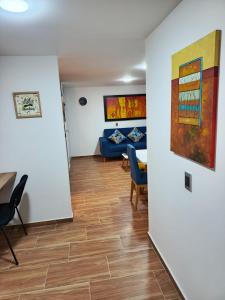 Apartamento Blue House Paipa في بايبا: غرفة معيشة بها أريكة وطاولة