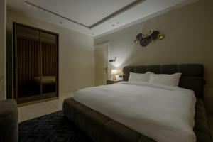 een slaapkamer met een groot wit bed en een raam bij شقة بطابع انيق بحي الملقا in Riyad