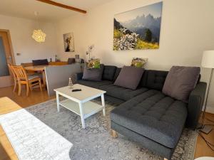 a living room with a couch and a table at Haus Lechbruck in Lechbruck
