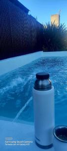 a water bottle sitting on a table next to a pool at DUPLEX ATARDECERES in Chascomús