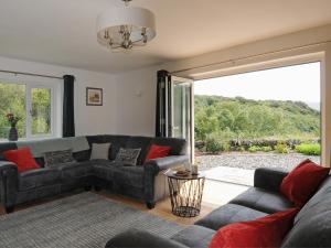 a living room with a couch and a large window at Bryn Derw in Barmouth