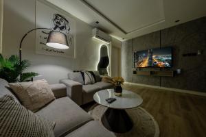 een woonkamer met een bank en een tafel bij شقة بطابع انيق بحي الملقا in Riyad