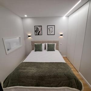 une chambre avec un grand lit avec des oreillers verts dans l'établissement Alameda Apartments 2, à Trofa