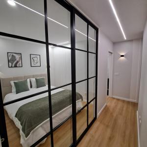 een slaapkamer met een bed met glazen wanden bij Alameda Apartments 2 in Trofa +6 foto's