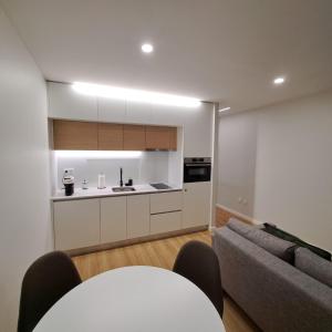 een keuken en woonkamer met een bank en een tafel bij Alameda Apartments 2 in Trofa