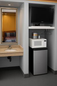 a bathroom with a sink and a flat screen tv at Liberty Inn Absecon Atlantic City in Galloway