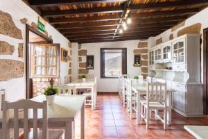 un restaurant avec des tables et des chaises blanches et une fenêtre dans l'établissement Casa Rural Vera De La Hoya, à San Miguel de Abona
